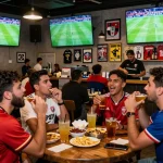 Fans enjoying Cá độ bóng đá at a vibrant sports bar with live matches.